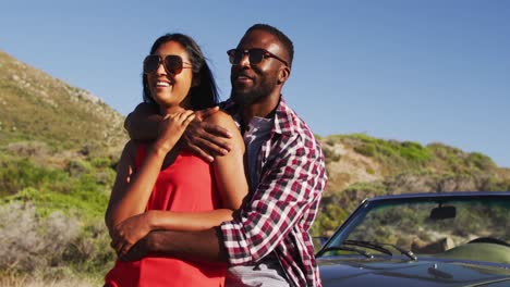 Afroamerikanisches-Paar-Umarmt-Sich,-Während-Es-Auf-Der-Straße-Neben-Einem-Cabrio-Steht