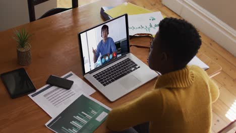 African-american-woman-using-laptop-on-video-call-with-male-colleague-working-from-home