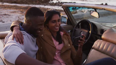 Afroamerikanisches-Paar-Macht-Ein-Selfie,-Während-Es-Im-Cabrio-Auf-Der-Straße-Sitzt