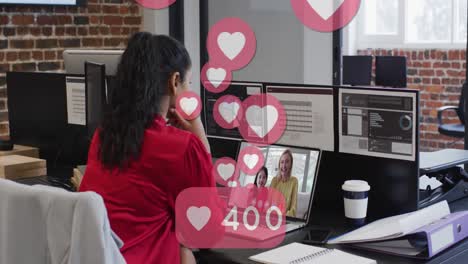 Animation-of-heart-icons-speech-bubble-with-heart-and-numbers-growing-over-woman-using-laptop-on-vid