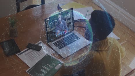 Animation-of-globe-of-connections-over-woman-using-laptop-on-video-call-in-background