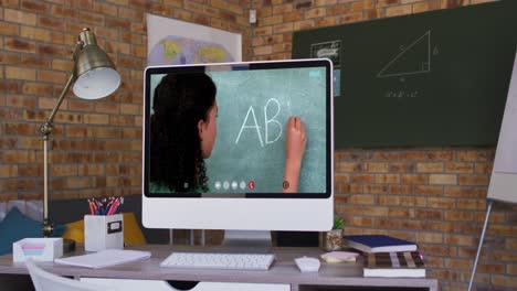 Mixed-race-female-teacher-displayed-on-computer-screen-during-video-call
