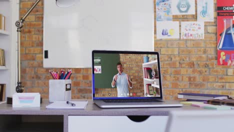 Caucasian-male-teacher-displayed-on-laptop-screen-during-video-call