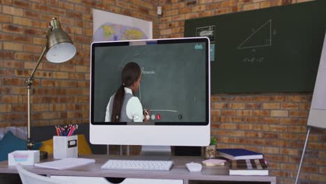 Mixed-race-female-teacher-displayed-on-computer-screen-during-video-call