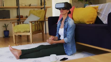 Smiling-caucasian-woman-wearing-vr-headset,-sitting-on-floor-at-home