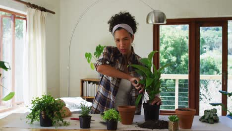 Caucasian-woman-vlogging,-potting-plants-at-home