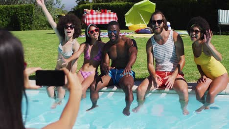 Group-of-diverse-friends-posing-for-a-picture-while-sitting-by-the-pool