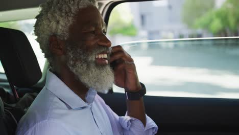 Afroamerikanischer-älterer-Mann,-Der-Auf-Dem-Smartphone-Spricht,-Während-Er-Im-Auto-Sitzt