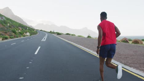 Hombre-Afroamericano-Haciendo-Ejercicio-Al-Aire-Libre-Corriendo-Por-Una-Carretera-Costera