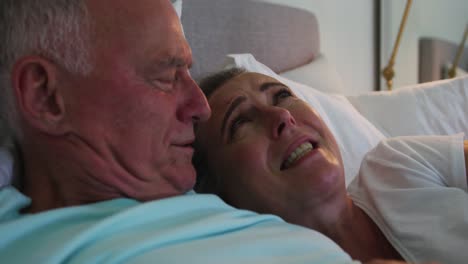 Close-up-of-caucasian-senior-couple-laughing-together-in-bed-at-home