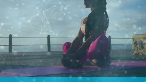 Animation-of-network-of-connections-over-woman-meditating-on-promenade-by-the-sea