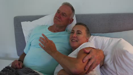Caucasian-senior-couple-embracing-each-other-in-bed-at-home
