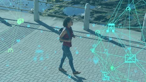 Animation-of-network-of-connections-with-technological-icons-over-woman-walking-on-park