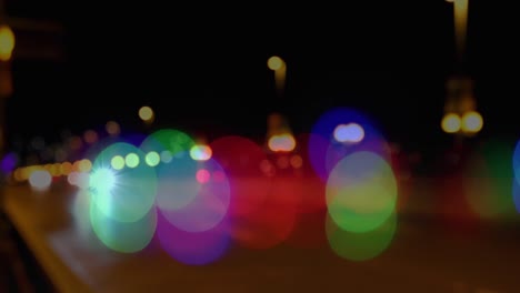 Animation-of-glowing-vibrant-spots-of-light-over-out-of-focus-road-traffic