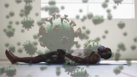 Animation-of-covid-19-cells-floating-over-african-american-man-wearing-face-mask-working-out