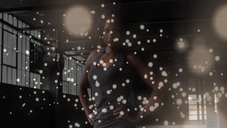 Digital-composite-video-of-yellow-particles-floating-against-portrait-of-african-american-woman