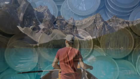 Animation-of-multiple-euro-coins-over-caucasian-man-canoeing-on-lake