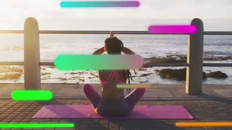 Animation-of-floating-colourful-shapes-over-woman-practising-yoga-on-promenade-by-the-sea