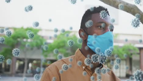 Animation-of-covid-19-cells-floating-over-african-american-man-wearing-face-mask