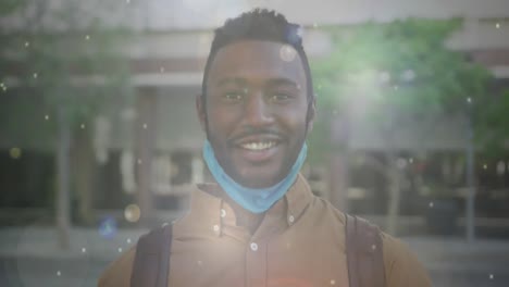 Animation-Von-Weißen-Punkten,-Die-über-Einem-Afroamerikanischen-Mann-Schweben,-Der-Die-Gesichtsmaske-Abnimmt