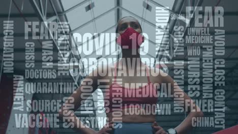 Coronavirus-Konzepttexte-Gegen-Eine-Afroamerikanische-Frau-Mit-Gesichtsmaske,-Die-Im-Fitnessstudio-Steht