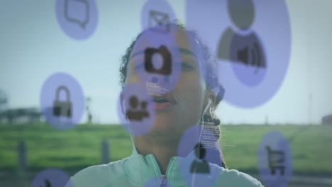 Vídeo-Compuesto-Digital-De-Iconos-Digitales-Flotando-Contra-Una-Mujer-Afroamericana-Que-Usa-Auriculares