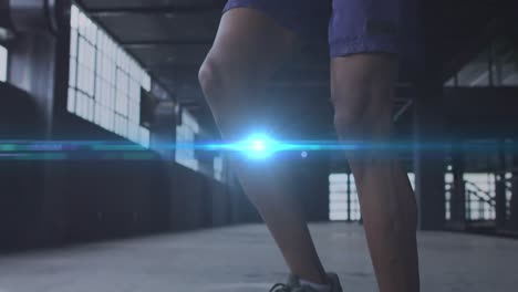 Digital-composite-video-of-blue-spot-of-light-against-african-american-man-jumping-rope