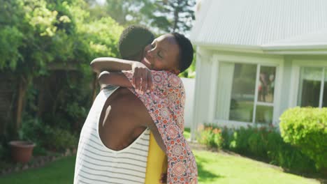 Glückliches-Afroamerikanisches-Paar,-Das-Sich-Im-Sonnigen-Garten-Umarmt