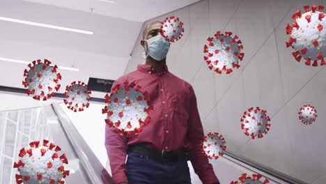 Covid-19-cells-floating-against-african-american-senior-man-wearing-face-mask-using-escalator