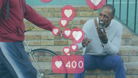 Heart-icon-with-increasing-number-floating-against-african-american-senior-man-talking-on-smartphone