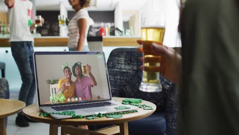 Woman-having-beer-on-laptop-video-call-celebrating-st-patrick's-day-with-friends