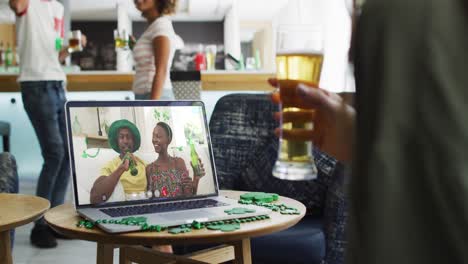 Woman-having-beer-on-laptop-video-call-celebrating-st-patrick's-day-with-friends
