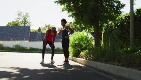Smiling-african-american-senior-couple-exercising-outdoors-taking-a-break