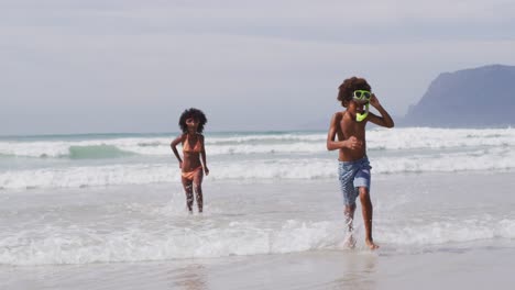 African-american-children-wearing-scuba-goggles-playing-at-the-beach