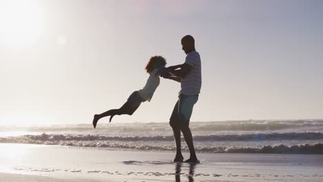 African-american-father-and-his-daughter-playing-on-the-beach