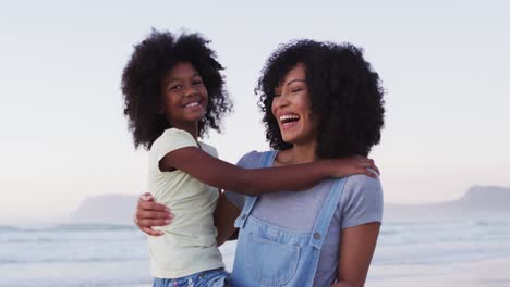 Porträt-Einer-Afroamerikanischen-Mutter-Und-Tochter,-Die-Gemeinsam-Am-Strand-Lächelt