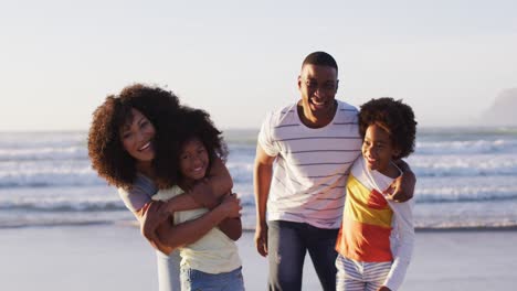 Porträt-Einer-Afroamerikanischen-Familie,-Die-Zusammen-Lächelt-Und-Am-Strand-Steht