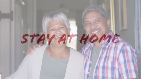 Animation-of-stay-at-home-text-over-smiling-senior-couple-embracing