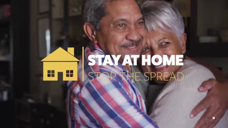 Animation-of-stay-at-home-stop-the-spread-text-over-senior-couple-embracing-at-home