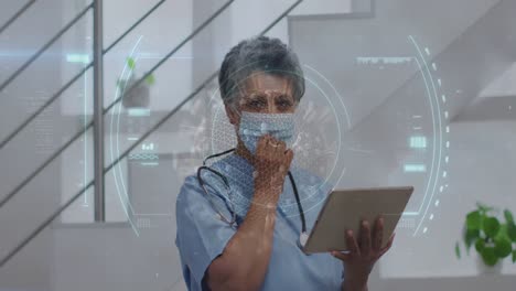Animation-of-scope-scanning-and-covid-19-cell-over-senior-female-doctor-in-face-mask-using-tablet