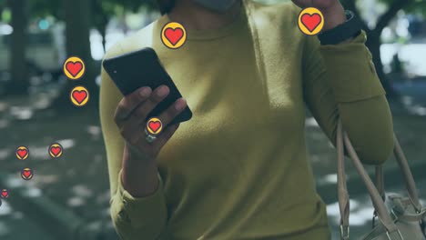 Multiple-heart-icons-floating-against-mid-section-of-woman-using-smartphone-and-drinking-coffee
