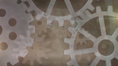 Animation-of-cogs-spinning-over-glowing-brown-background