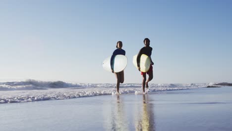 Afroamerikanisches-Paar-Läuft-Mit-Surfbrettern-Am-Strand