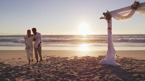 Afroamerikanisches-Verliebtes-Paar-Heiratet,-Geht-Bei-Sonnenuntergang-Am-Strand-Spazieren