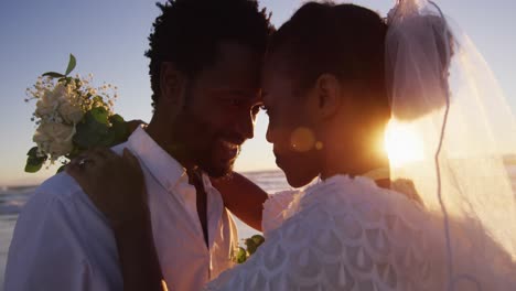 Afroamerikanisches-Verliebtes-Paar-Heiratet-Und-Schaut-Sich-Bei-Sonnenuntergang-Am-Strand-Andere-An