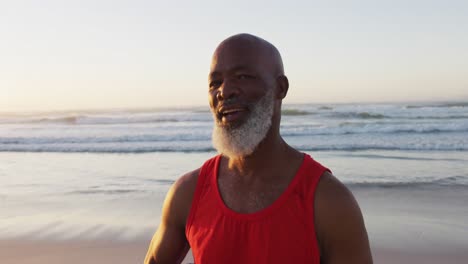 Lächelnder-älterer-Afroamerikanischer-Mann,-Der-Am-Strand-Spaziert