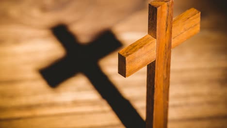 Christliches-Kreuz-Aus-Holz,-Das-Schatten-Auf-Die-Holzoberfläche-Wirft