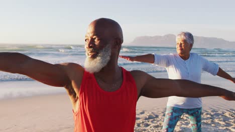 Älteres-Afroamerikanisches-Paar,-Das-Yoga-Am-Strand-Praktiziert