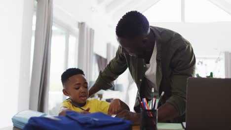 Afroamerikanischer-Vater-Und-Sohn-Machen-Hausaufgaben-Und-Benutzen-Gemeinsam-Einen-Laptop