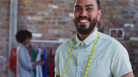 Happy-mixed-race-male-fashion-designer-looking-at-camera-and-smiling
